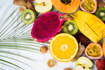 Exotic fruits and tropical leaves on table