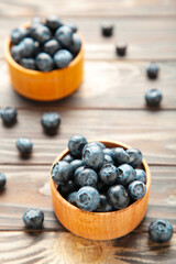 Blueberries in a bowls on brown wooden table. Vertical foto
