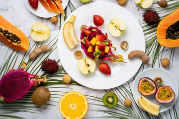 Exotic fruits and tropical leaves on table