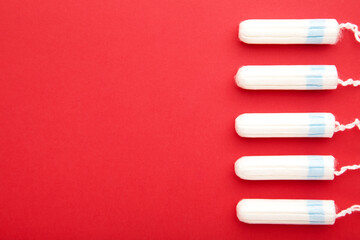 Menstrual tampons on a red background. Cotton tampon for women - obrazy, fototapety, plakaty