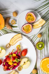 Exotic fruits and tropical leaves on table