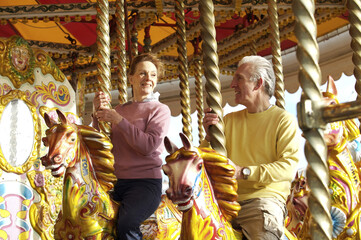 A couple smiling at each other on the carousel