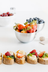 Summer fruit bruschetta with white chocolate spread, bananas, raspberries and strawberries. Breakfast snacks. 