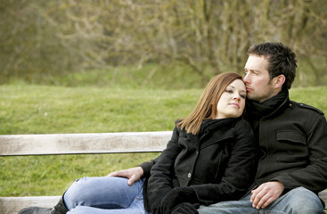 Happy couple sitting at the park