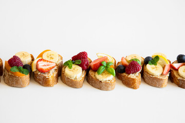 Summer fruit bruschetta with white chocolate spread, bananas, raspberries and strawberries. Breakfast snacks. 