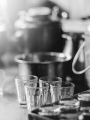 tea glass cups with utensils in the background in monochrome