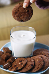 Woman dipping cookie into a glass of milk