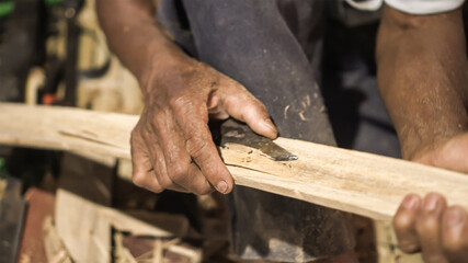 Elder man hand use knife cutting bamboo craftman work in Thailand