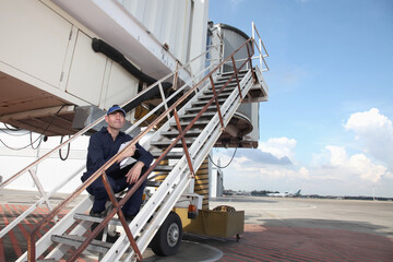 Mechanic standing on stairs of passenger boarding bridge