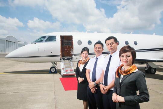 Pilots and flight attendants standing by private jet