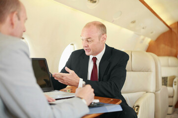 Businessmen working in private jet