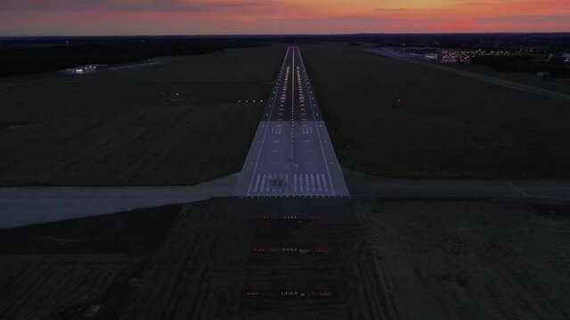 Empty airport runaway with braking and maneuvering marks, designation 29 and all navigation lights on at the colorful sunset, clear for airplane landing or taking off in Wroclaw  airport