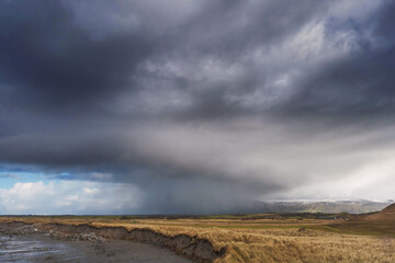 Rain clouds cover Benbulben flat top mountain in county Sligo; Ireland. Nobody, Rosses point beach