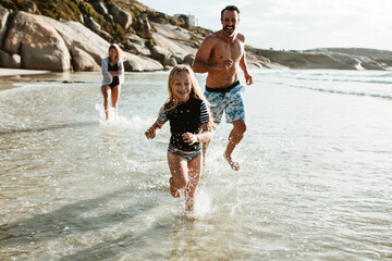 Family running in water at the beach - Powered by Adobe