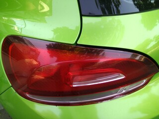 The red headlight on a green car.