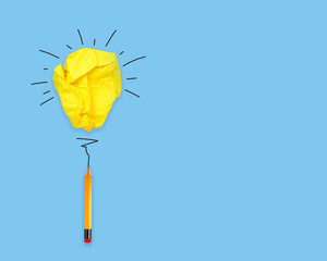 Yellow paper light bulb with pencil on blue background