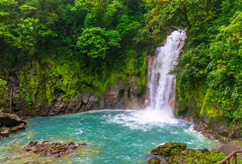 Waterfall and natural pool with turquoise, blue water of Rio Celeste in Tenorio Volcano national...