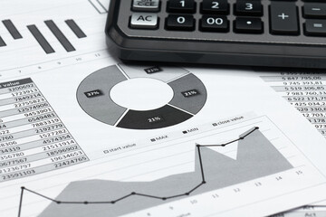 business office desk closeup - financial reports, analysis and accounting, set of documents, tables and graphs, various items for bookkeeping, calculator