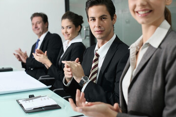 Business people clapping hands in conference room