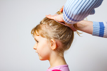 Mama is making hairstyle to her daughter