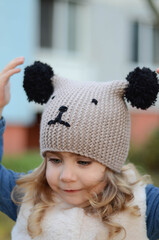 Picture of a blonde toddler girl in the funny knitted hat