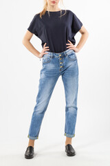 girl in jeans shows off jeans on white background close up, blue jeans