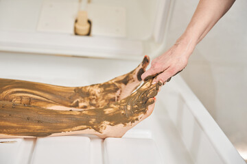 Putting nourishing body mask on the toes for spa treatment