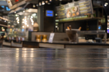 Empty wood table top and blur of food court or cafe restaurant in dark night background/selective focus .For montage product display