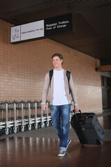 Fototapeta na wymiar Man pulling his luggage pass luggage carts at the airport