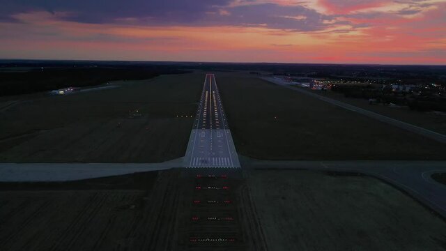 Empty airport runaway with braking and maneuvering marks, designation 29 and all navigation lights on at the colorful sunset, clear for airplane landing or taking off in Wroclaw  airport
