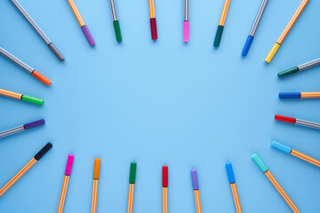 Naklejka premium Colored markers making a circle with copy space in the center on a blue background. Back to school, design, creativity concept and crafts.