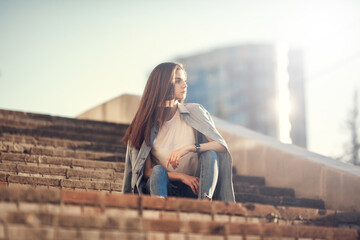 Fashion hipster cool girl relaxing on city street