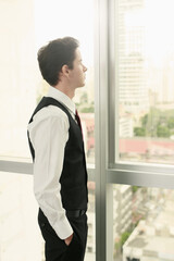 Fototapeta premium Businessman looking out of the glass window
