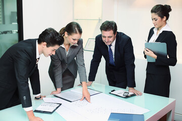 Business people reviewing blueprints together