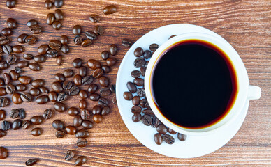 Coffee cup and coffee beans on old wooden background. Copy space for text.