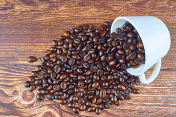 Coffee beans in the cup on wooden table.