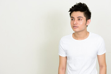 Obraz premium Portrait of happy young handsome Asian man with braces thinking
