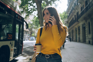 Lifestyle portrait of happy attractive casual woman walking in the city on a sunny day, beautiful young girl dressed in casual style  girl dressed in casual style talking on smartphone