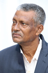 Calm or casual looking senior Indian man face portrait on white background.  Old man looking side way.