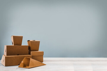 Different types of brown cardboard packaging. For fast food, folding, large and small. The concept of production and design of paper products. Place for text. Selective focus.