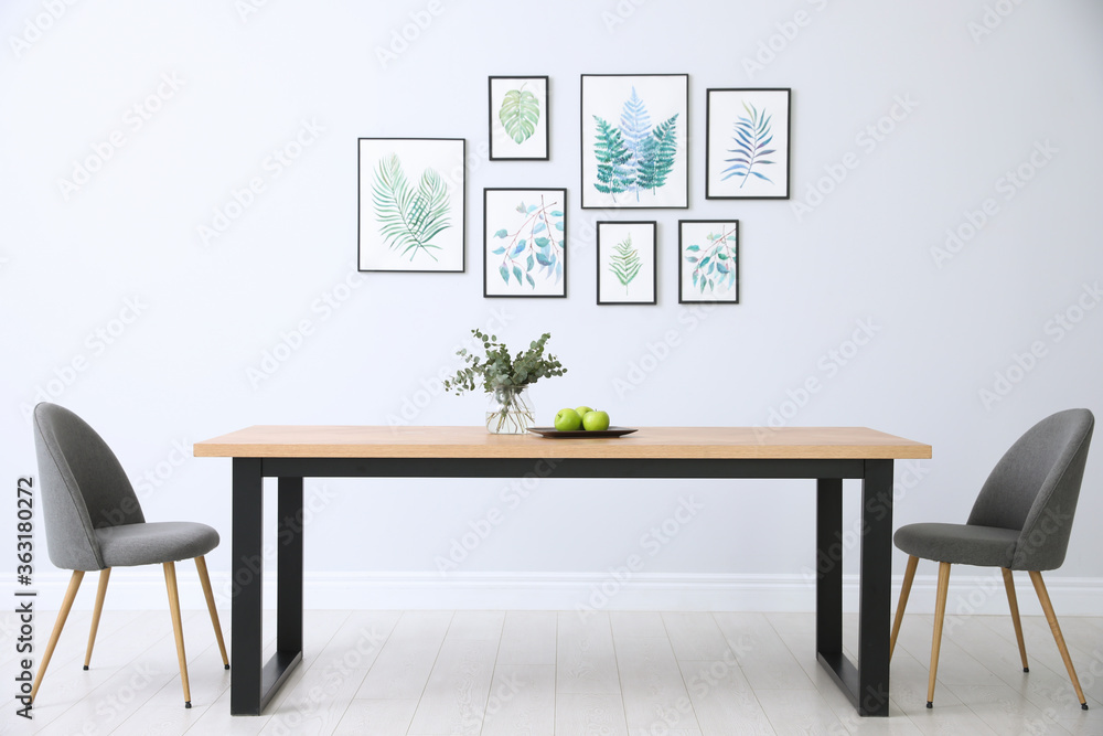 Canvas Prints Stylish room interior with modern table, chairs and paintings of tropical leaves. Idea for design