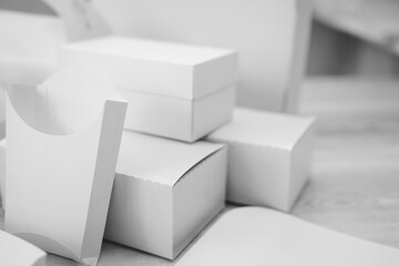 Different types of cardboard packaging. For fast food, folding, large and small. The concept of production and design of paper products. Place for text. Selective focus. Black and white