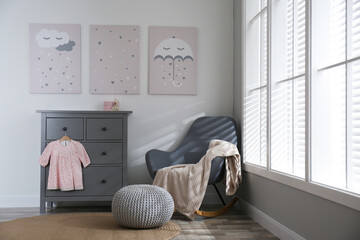 Baby room interior with cute posters and rocking chair