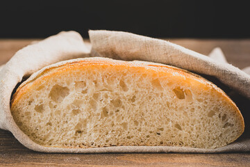 Fresh baked white bread slice slice on a dark background. Front view copy space.