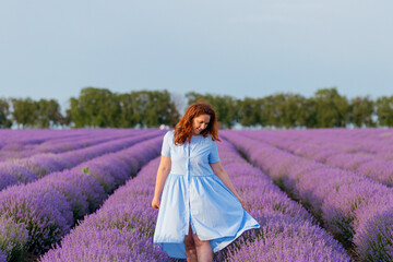 Beautiful and happy woman walks in a lavender field