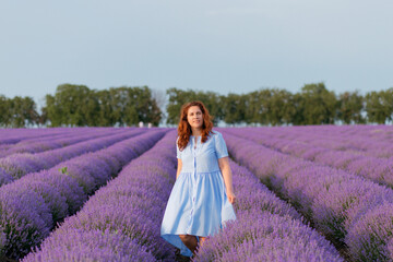 Beautiful and happy woman walks in a lavender field