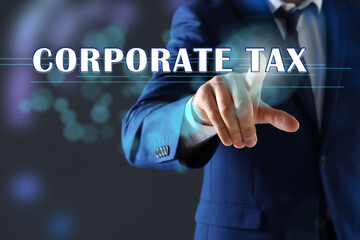 Corporate tax concept. Man touching virtual screen on color background, closeup