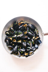 Steamed mussels cooked on a big pot  fresh fish mussels daily taken from sea cooked on a white background