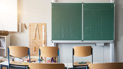 CORONAVIRUS - School closed - Empty classroom with high chairs and empty blackboard 