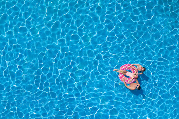 Happy family with inflatable ring in swimming pool, top view. Space for text